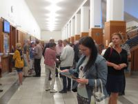 Návštěvníci přicházejí na přednášku o Salcburku, dostávají aktuální informační materiály